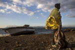 LESBOS, GREECE - OCTOBER 25: A refugee wrapped in an emergency blanket stands on Iftalou beach on Lesbos next to a refugee shipwreck. Colder weather and rough seas continue to cause deaths at sea as thousands travel in overcrowded small rafts. According to the IOM, an estimated 100,000 people landed in Greece, an average of almost 4,500 per day in late October and November. Nearly all of those entering Greece on a boat from Turkey are from the war zones of Syria, Iraq and Afghanistan. (Photo by Paula Bronstein)