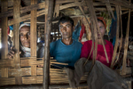 MAYEBON - NOV 8: Albella (left) Abdul Hamid,40(center) and Moria Katu (right) look through the window of a thatched hut at the Mayebon IDP camp where registration has taken place forcing the residents of the camp to list themselves as Bengali not Rohingya. The new policy is called the Rakhine Action Plan. (Paula Bronstein for The Washington Post)