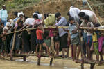 Rohingya desperately try to cross a river on a crowded  makeshift bamboo bridge at Kutpalong camp.For years Buddhist majority Myanmar has struggled to deal with a deeply rooted hatred towards the Rohingya in western Rakhine state. The Muslim ethnic minority were always considered illegal immigrants from Bangladesh and denied the rights of citizenship. According to Human Rights Watch, the 1982 laws {quote}effectively deny to the Rohingya the possibility of acquiring a nationality ”. Myanmar’s government also enforced severe restrictions on freedom of movement, state education and civil service jobs and health care. The refugee emergency unfolded in late August after an attack on state security forces by Rohingya insurgents, triggering a brutal military crackdown that has forced more than half of the country’s 1.1 million population fleeing to neighboring Bangladesh creating the fastest cross-border exodus ever witnessed with over 655,000 new arrivals. 