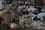  Donetsk, People's Republic (DPR) : Galina Mikhailovna , age 79, waits for customers at a second hand market in suffering during a cold winter day in February. She sells used goods that others give to her in the market for pensioners, sits in the snow with some street dogs. She has no pension, she never went to Ukraine to register, claims she can‚Äôt afford to travel to the other side every 57 days which is required by the government. She is in  debt so can‚Äôt afford to pay for heat and water in her apartment anymore. 