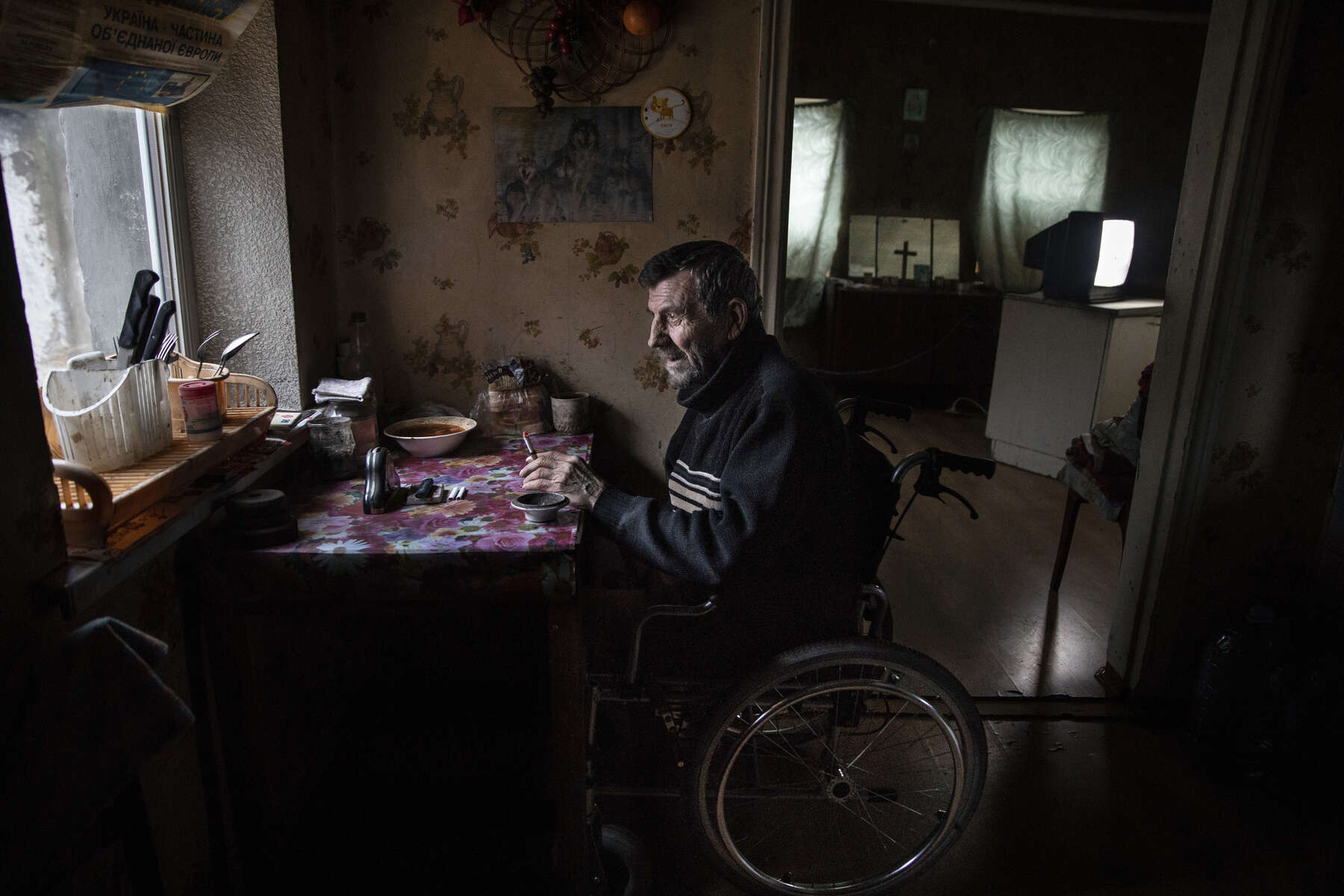 Avdiivka: Vladimir Mamoshyn, age 65, sits in his wheelchair, his wife died in 2010, now he lives alone, his children abandoned him. He resides in the war-torn  Avdiivka village, less than a kilometer from the contact line where daily shelling and gunfire can be heard. In 2016, Vladimir lost his leg due to a vascular disease, with poor access to health facilities along with inadequate health care. After having a heart attack a few months later in 2017 he lost the use of his left hand, now he lives in a wheelchair depending on family and  friends to help him.