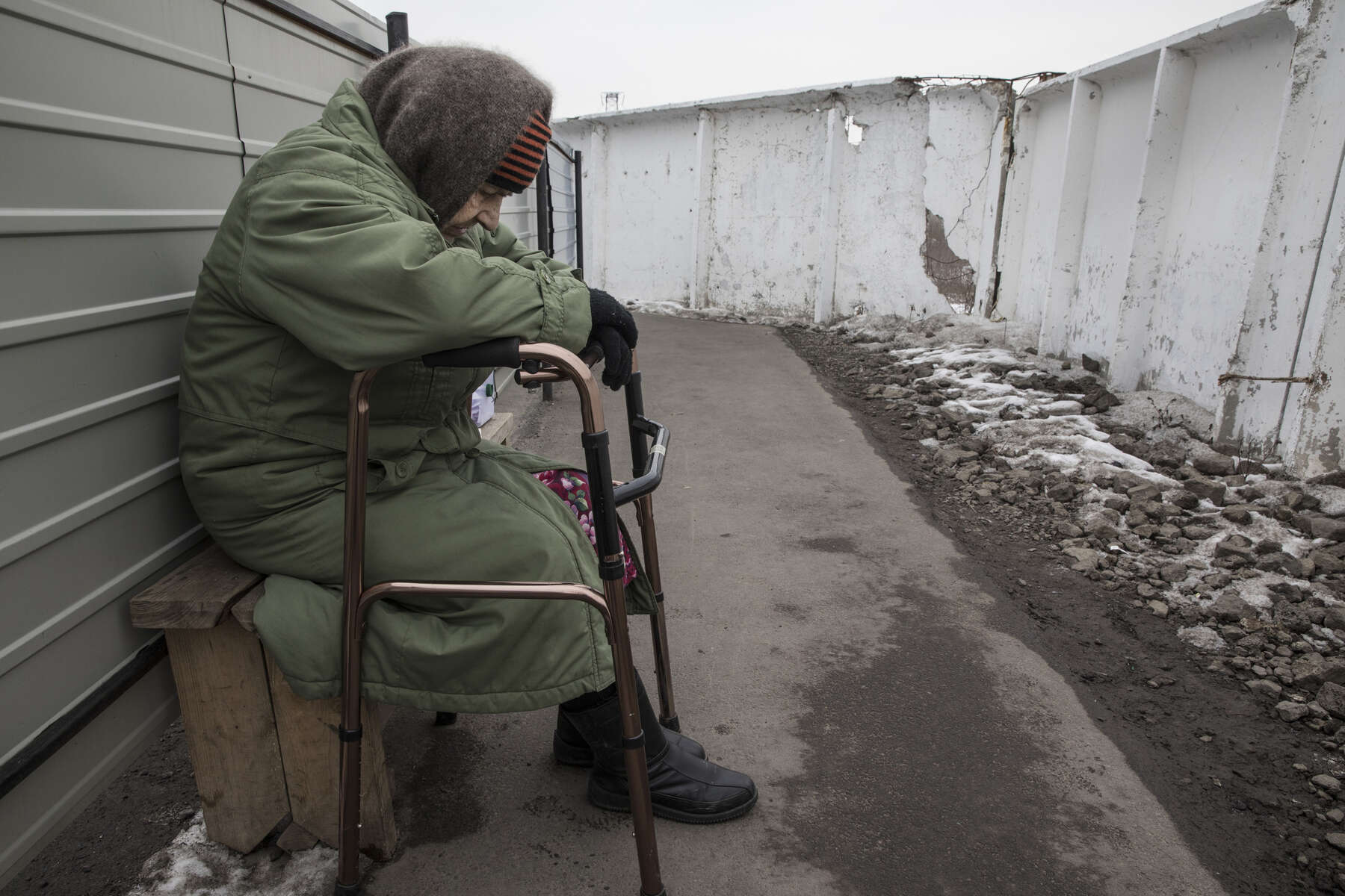Mayorsk : An elderly handicapped woman rests after trying to walk the long distance in the cold to cross the border from Donetsk to the government-controlled territory of Ukraine in order to collect her pension. There is no regular wheelchair assistance when crossing the border area. 