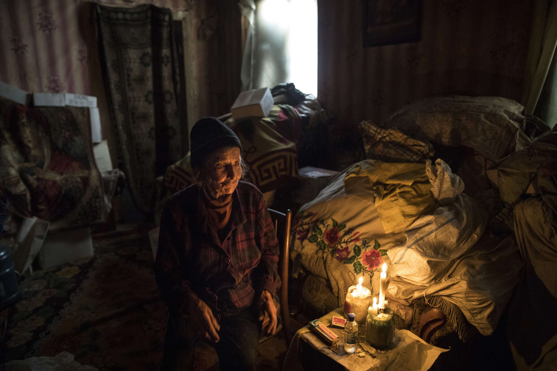Opytne, Eastern Ukraine:  Mariya Gorpynych, age 76, lives alone. She speaks with tears in her eyes while talking about the death of her son. Victor,48 was killed due to the war in 2016, he was fatally injured by shelling that hit the home. He died in her hands. Her husband, died in the same year from a heart attack  from extreme stress of living too close to the front line. Mariya refuses to leave her village because her family are buried there.{quote}I have nowhere to flee, my whole family is buried here.{quote}  {quote}I got used to the continued shelling.{quote} Opytne is a war torn village on the contact line where only 43 people are left due to the dangers. 