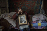  Katerinovka, Lugansk: Natalia Reshetnyakova, age 83 holds a portrait of her late husband who she was married to for over 50 years. She lives alone now. The only thing left reminding her of her husband is this portrait. The population of Natalia's village comprises less than 300 people. The village is exposed to the sniper’s fire as the contact line is just few kilometers away.