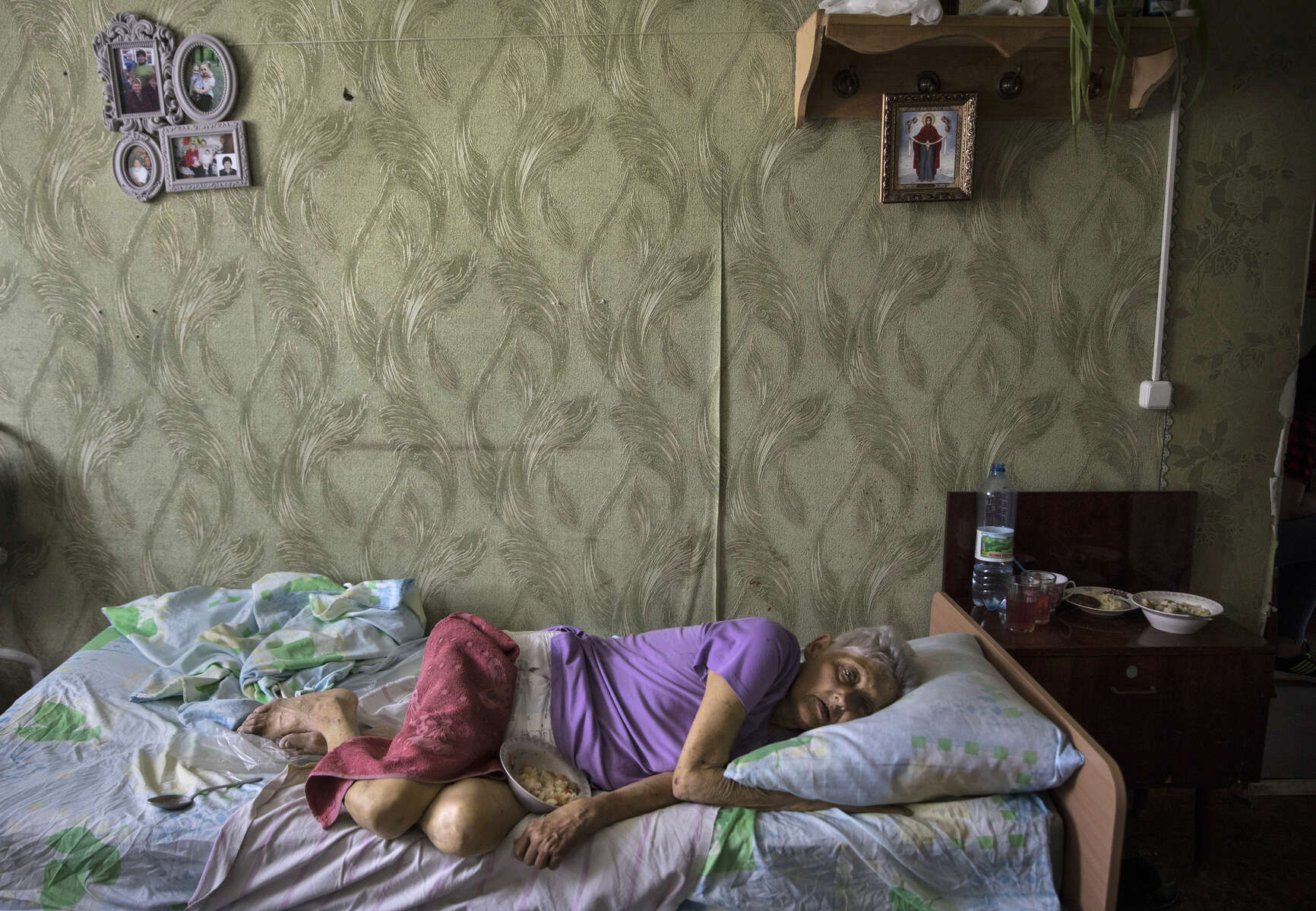 Valentina Iosipovna, age 76 lays in bed waiting for staff to feed her at the Druzhkovka nursing home. 