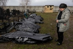 BUCHA: Valya grieves over the body of her husband Alexander Kudin  on April 8,2022 as body bags line the Bucha city cemetery. 
