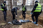 IRPIN: Irpin criminal investigators and police gather evidence after exhuming the body of a man and two women who died from shelling, taken to another area in the neighborhood for burial. 