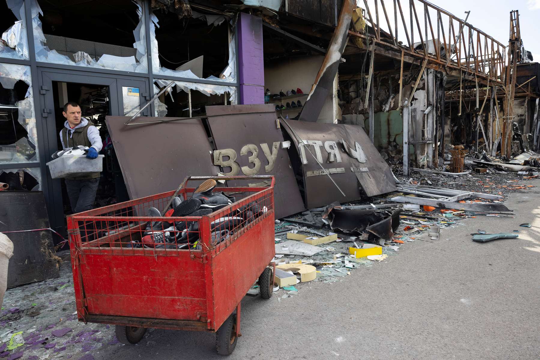 Kharkiv: After a shopping center was shelled workers take out the shoes from a destroyed sporting goods store next to the  Heroiv Pratsi metro station in the north of the city that has been hit by constant Russian attacks. 