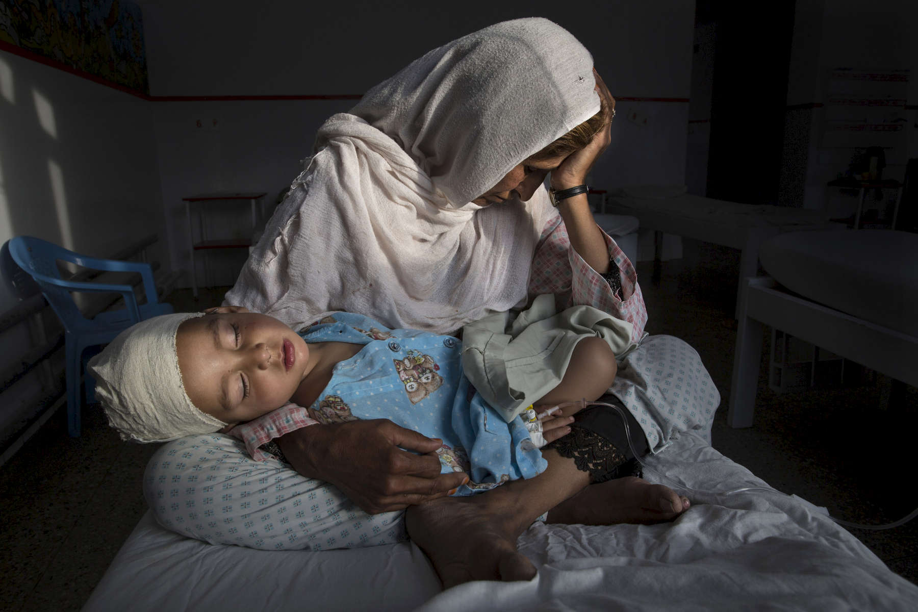 KABUL, AFGHANISTAN -MARCH 29, 2016:  At the Emergency hospital Najiba holds her nephew Shabir, age 2,  who was injured from a bomb blast which killed his sister in Kabul on March 29, 2016. Najiba had to stay with the children as their mother buried her daughter. Afghan civilians are at greater risk today than at any time since Taliban rule. According to UN statistics, in the first half of 2016 at least 1,600 people had died, and more than 3,500 people were injured, a 4 per cent increase in overall civilian causalities compared to the same period last year. The upsurge in violence has had devastating consequences for civilians, with suicide bombings and targeted attacks by the Taliban and other insurgents causing 70 percent of all civilian casualties.  