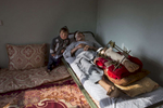 KABUL, AFGHANISTAN -APRIL 9, 2016:  Abdul Hussain Ayoobi, is seen at home with his son Ali Akbar, 3, who is trying to understand why his father hurts so much all the time. Abdul, a carpenter was one of the seriously wounded victims for Tolo TV. The employees had finished a day’s work at Tolo TV, one of Afghanistan’s largest entertainment channels, when they boarded a company bus in Kabul that was rammed by a car driven by a Taliban suicide bomber. Seven people were killed and at least 25 wounded in the attack.Afghan civilians are at greater risk today than at any time since Taliban rule. According to UN statistics, in the first half of 2016 at least 1,600 people had died, and more than 3,500 people were injured, a 4 per cent increase in overall civilian causalities compared to the same period last year. The upsurge in violence has had devastating consequences for civilians, with suicide bombings and targeted attacks by the Taliban and other insurgents causing 70 percent of all civilian casualties.  