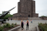 Twin girls walk in front of a soviet SA-2 missile exposed in the Victory park of Yerevan on May 6, 2018