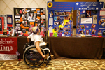 A visitor reads about the contestants; each woman creates a display table and board about her life and work, including awards, volunteer work, news clippings and occasionally information about the circumstances that led to her disability.