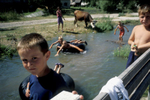 Children play in the river that runs through the village of Vesela, which has had a refugee return rate of some ninety percent of its pre-war population of Muslims, Serbs and Croats. Vesela has been hailed as a sucess story by Bosnian officials; in the aftermath of \{quote}ethnic cleansing\{quote} and genocide many towns and villages remain heavily populated by one group or another, with many refugees reluctant to return to the homes they fled during the war. July 2001.