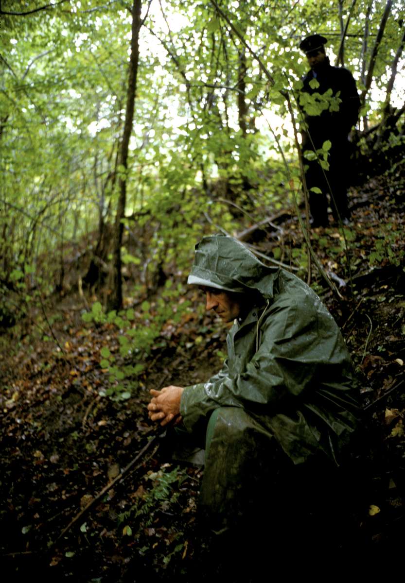 A gravedigger takes a break during an exhumation of a Muslim man killed by Serb neighbors in 1992. October 2000.