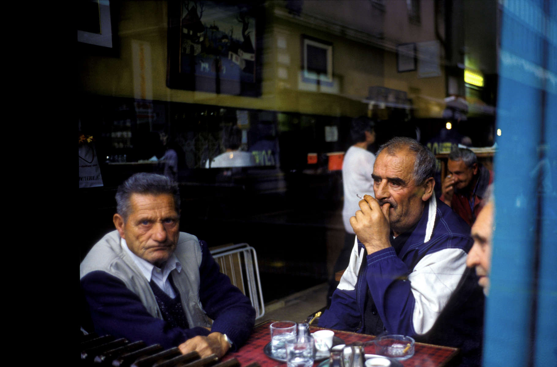 Men smoke cigarettes and drink coffee at one of Sarajevo\'s many coffeehouses. Drinking coffee is a local pasttime, but also a reflection of Bosnia\'s high unemployment rate, which hovers near fifty percent. April 2002.