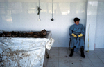 A forensic anthropologist takes a break from cleaning the remains of a recenty-exhumed victim of the Serbs\' 1992 \{quote}ethnic cleansing\{quote} campaign against Muslims. July 2001.