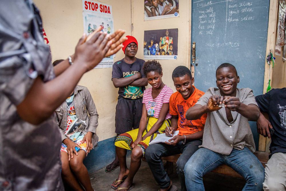 A young Congolese boy tries to open a condom packet during a workshop about safe sex and contraceptives at one of the rare youth-friendly clinics in Kinshasa. September, 2016.