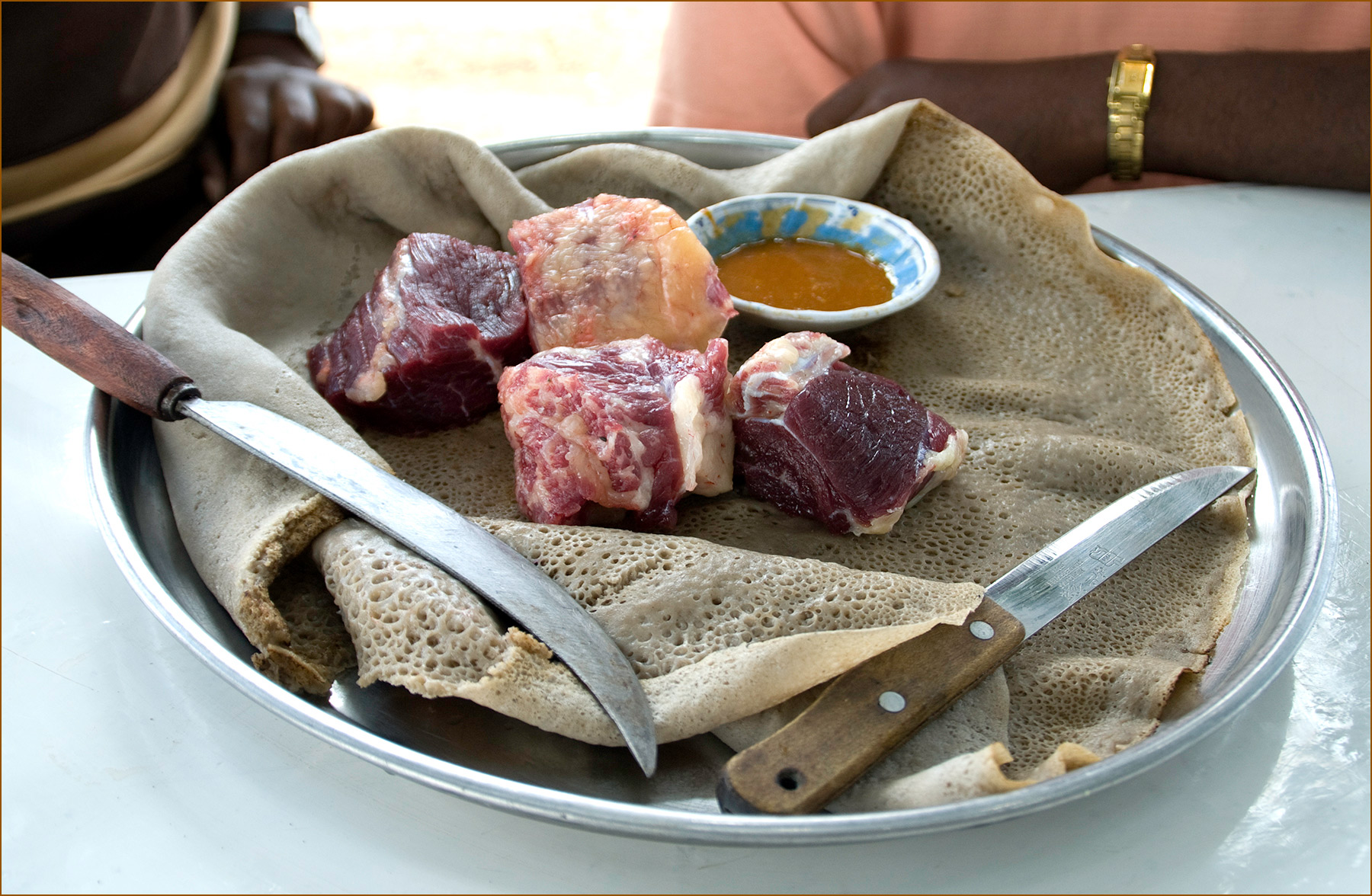 Ethiopia-Raw-beef-chunks-on-injera-with-hot-sauce-Carl-Kravats-Photography