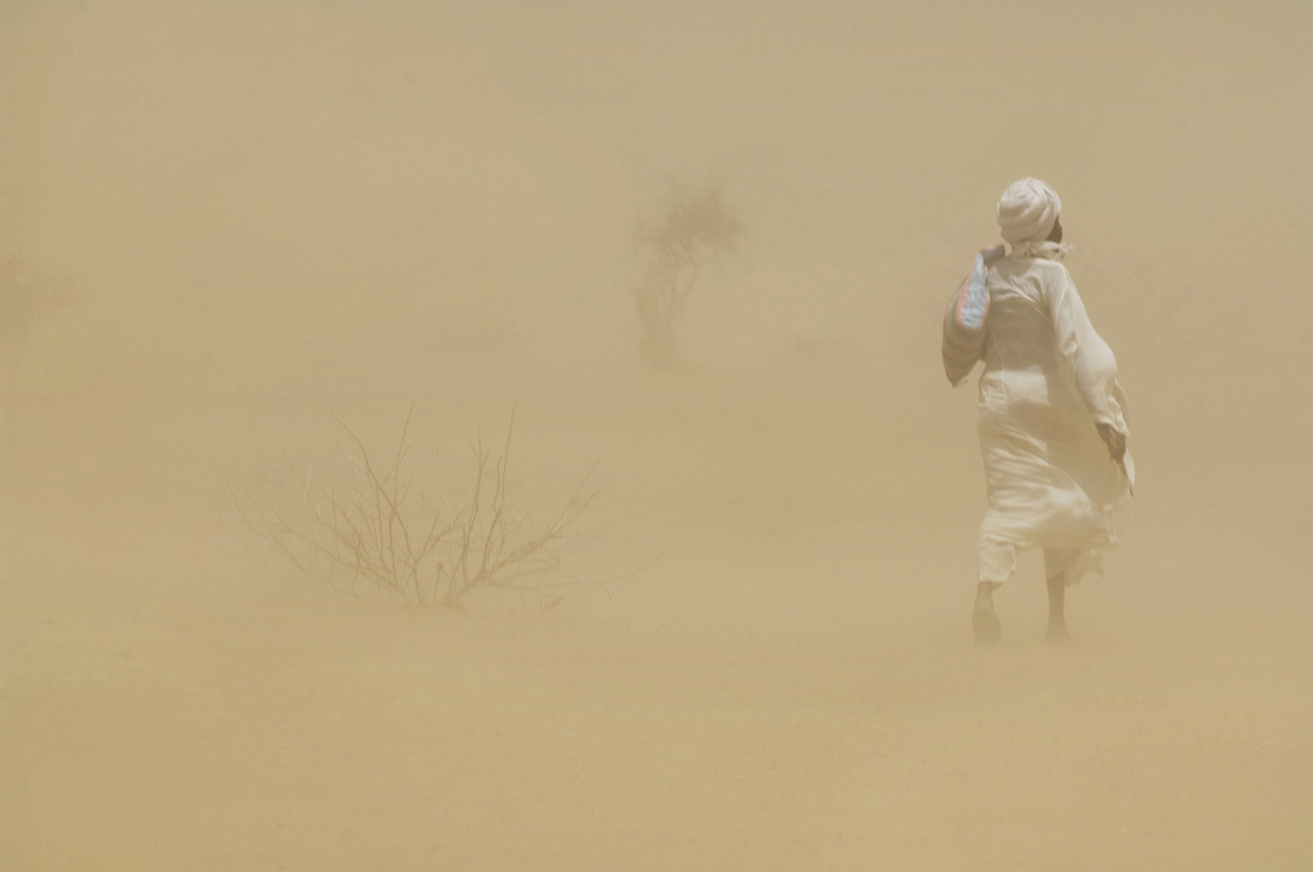 A man walks through a haboob (intense sandstorm typical in Sudan and other arid regions).Kulbus, Western Darfur State