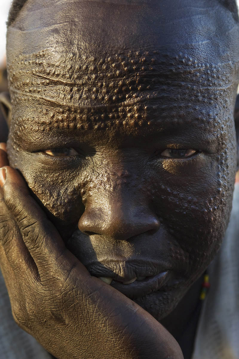 A Nuer man with detailed scarification on his face.  Many Sudanese tribes practice scarification and though efforts to curb the rite of passage for safety and hygienic reasons have reduced its frequency, it continues in rural areas.Bentiu, Unity State