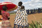 Young girls watch as newly trained Southern Sudan Police Service cadets parade on the airstrip.  Many SPLA soldiers were transferred to other uniformed services including the police, prisons and wildlife following the signing of the CPA.Torit, Eastern Equatoria State