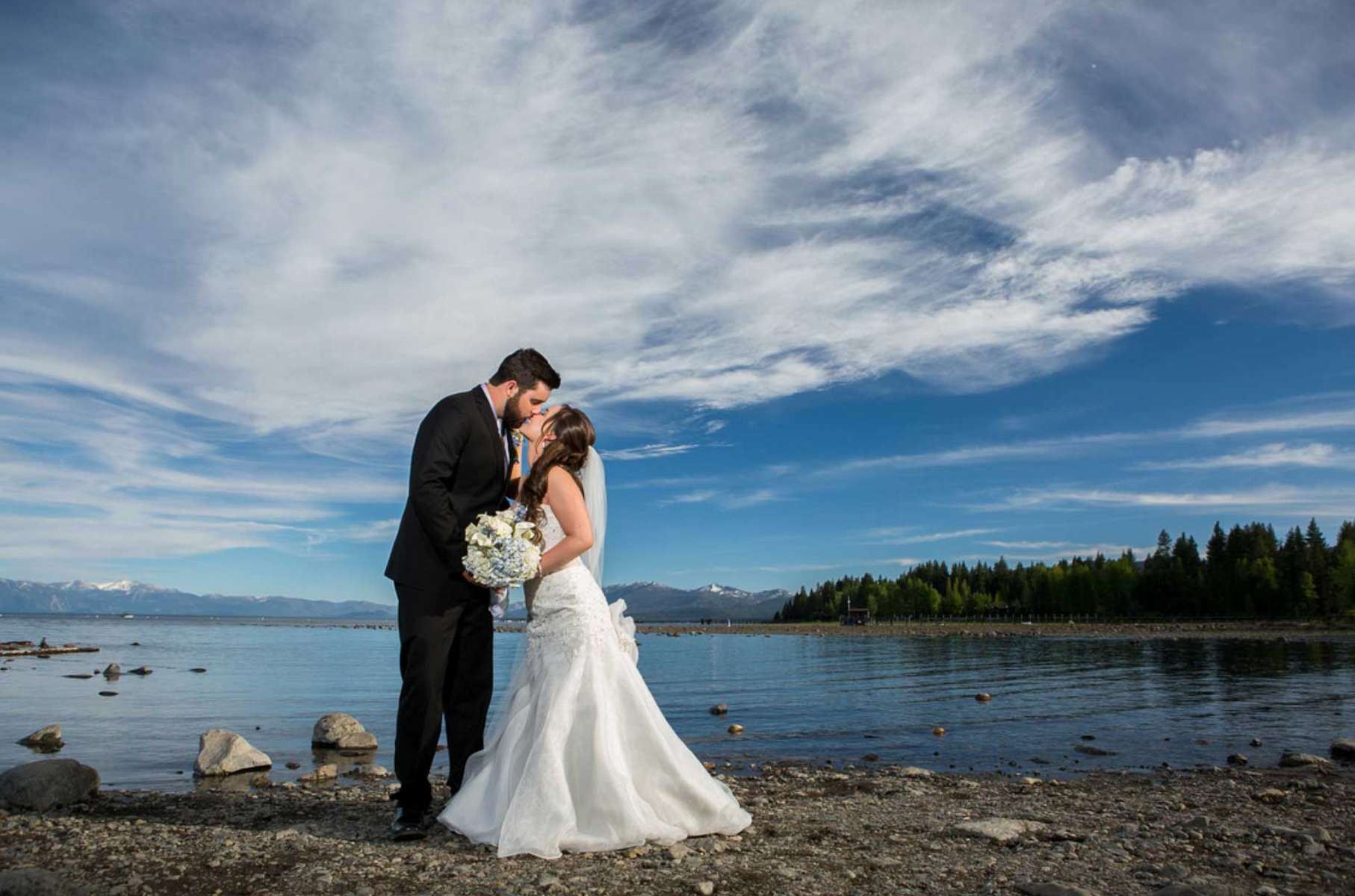 Nestled amidst the breathtaking beauty of Lake Tahoe, Sarah and John's wedding was nothing short of a dream come true. The serene, crystal-clear waters of the lake provided a stunning backdrop for their special day, reflecting the love and commitment they shared. Surrounded by towering pine trees and the majestic Sierra Nevada mountains, their ceremony was a picture-perfect moment that blended nature's grandeur with their heartfelt vows. As the sun dipped behind the mountains, casting a warm, golden glow over the festivities, friends and family gathered to celebrate this union in a rustic lakeside venue. From the intimate ceremony by the water's edge to the lively reception under the stars, it was a day filled with love, laughter, and the unparalleled magic of Lake Tahoe.