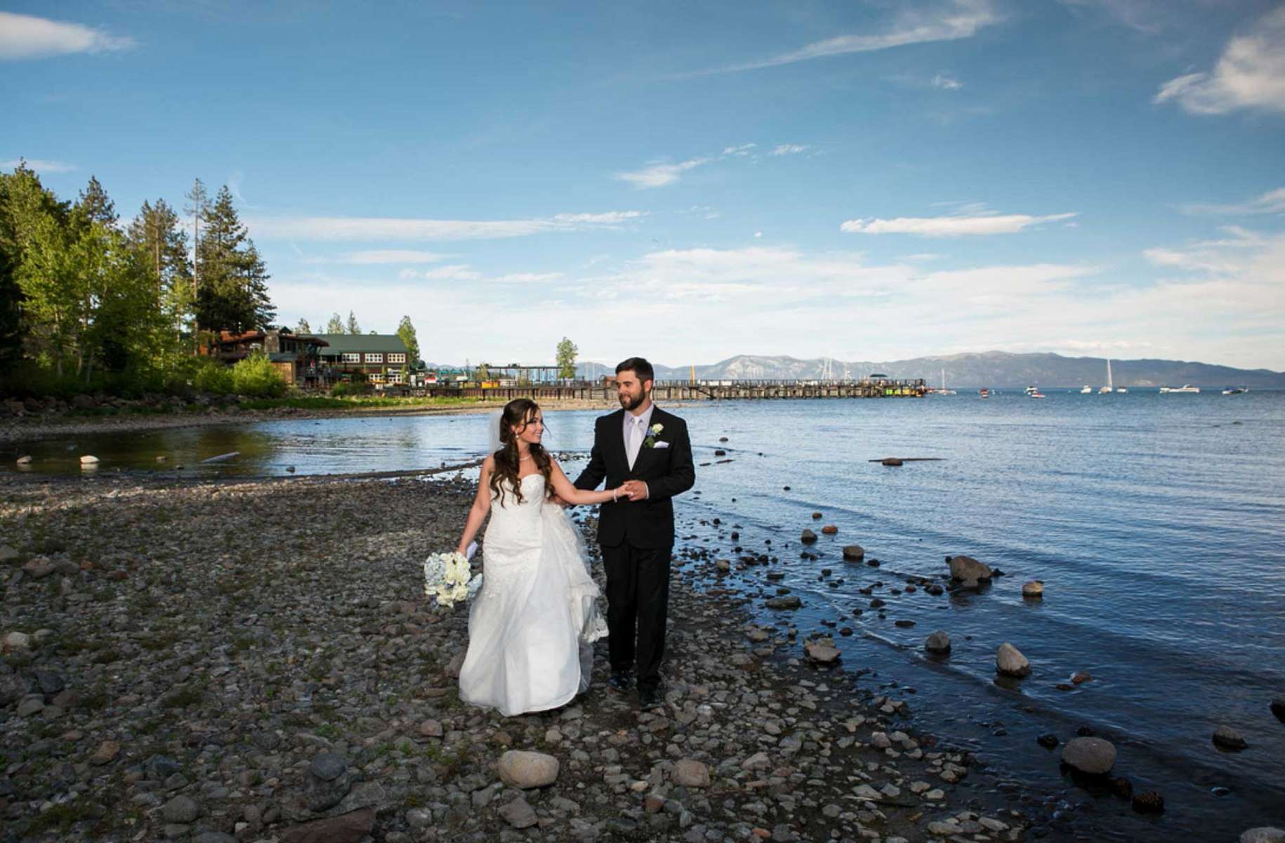 Nestled amidst the breathtaking beauty of Lake Tahoe, Sarah and John's wedding was nothing short of a dream come true. The serene, crystal-clear waters of the lake provided a stunning backdrop for their special day, reflecting the love and commitment they shared. Surrounded by towering pine trees and the majestic Sierra Nevada mountains, their ceremony was a picture-perfect moment that blended nature's grandeur with their heartfelt vows. As the sun dipped behind the mountains, casting a warm, golden glow over the festivities, friends and family gathered to celebrate this union in a rustic lakeside venue. From the intimate ceremony by the water's edge to the lively reception under the stars, it was a day filled with love, laughter, and the unparalleled magic of Lake Tahoe.