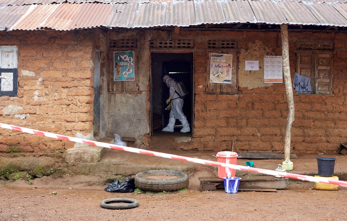 A decontamination worker (student nurse) cleans the house after a gentleman died from Ebola in the home. Tonkolili, Sierra Leone