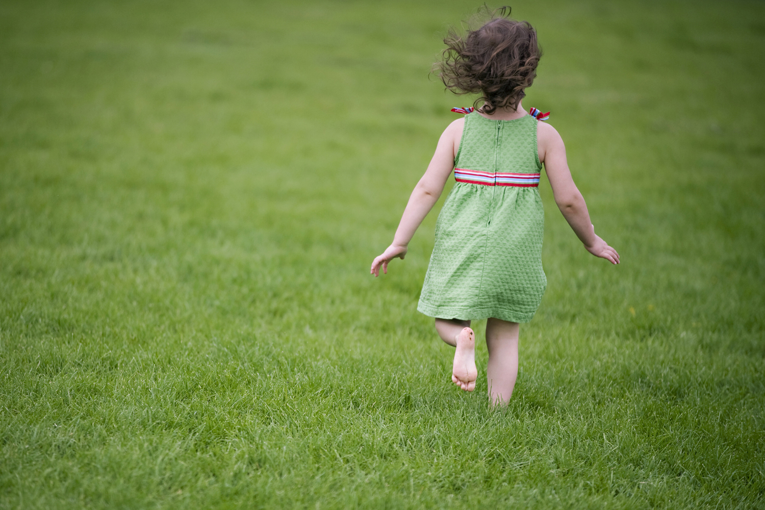 girl running through the grass during Hoboken family portrait session