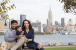Family of three in Hoboken against the NYC skyline for their family photos