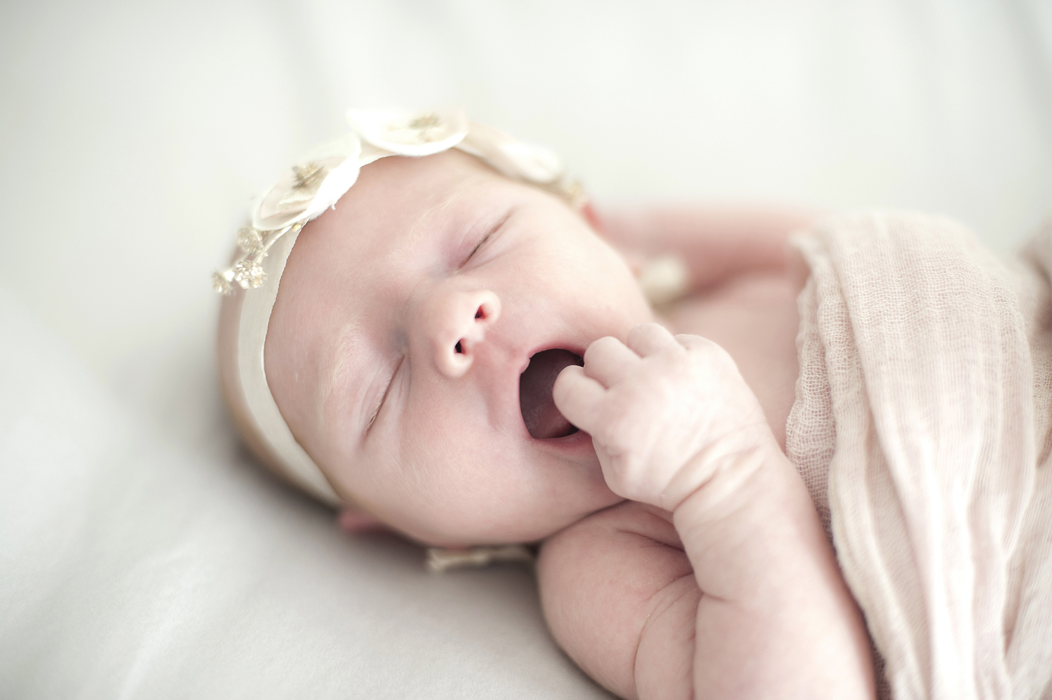 newborn baby girl yawning during her newborn photo session