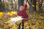 girl throwing leaves during fall family session in Central Park