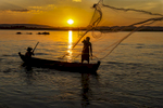 Fisherman Throwing Net at Sunset