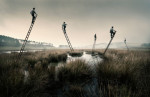 Laurence Winram Photography. Men on top of floating ladders in a misty landscape