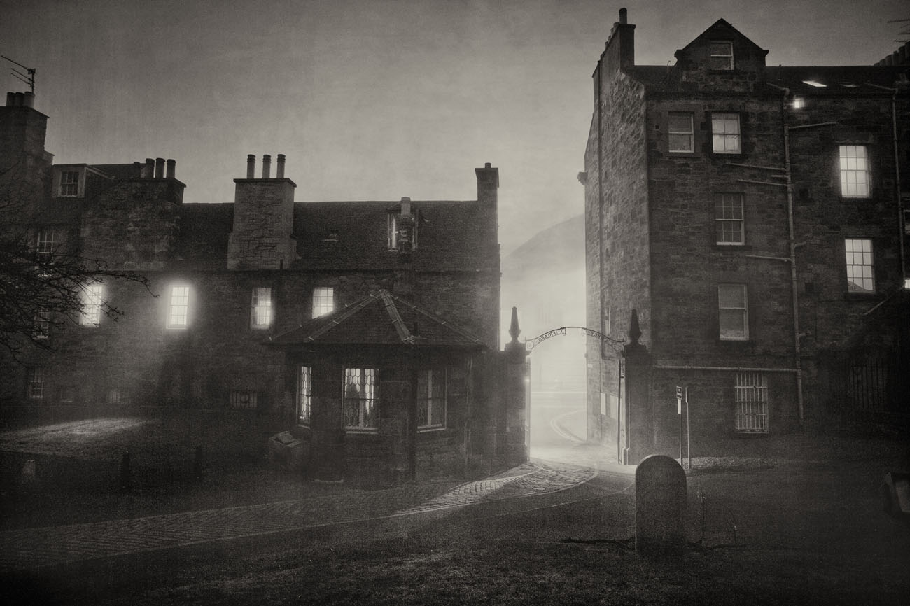 graveyard view with backs of houses in Greyfriars kirk in Edinburgh. Black and white photo on a foggy night.