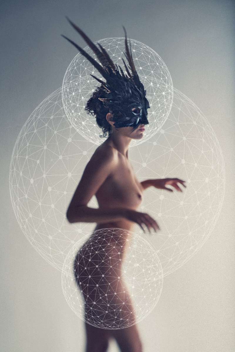 beautiful nude woman wearing a feather mask in a studio with geometric shapes added as a graphic