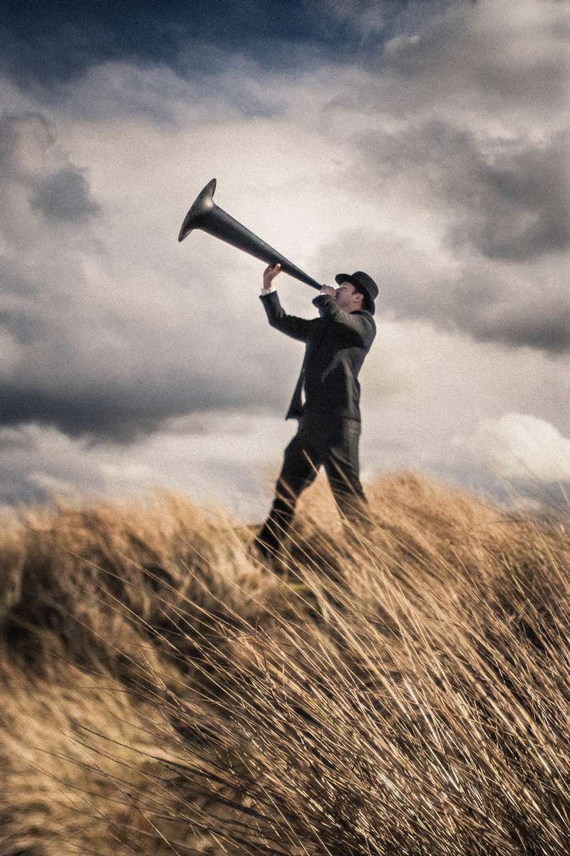 a man blowing a giant horn