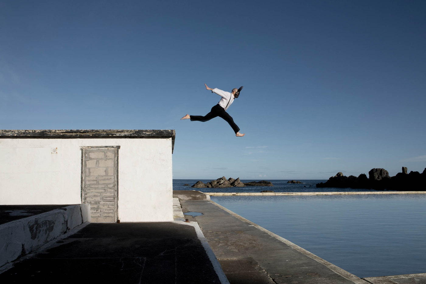 man leaping into a pool with a hare mask on at  Tarlair Lido