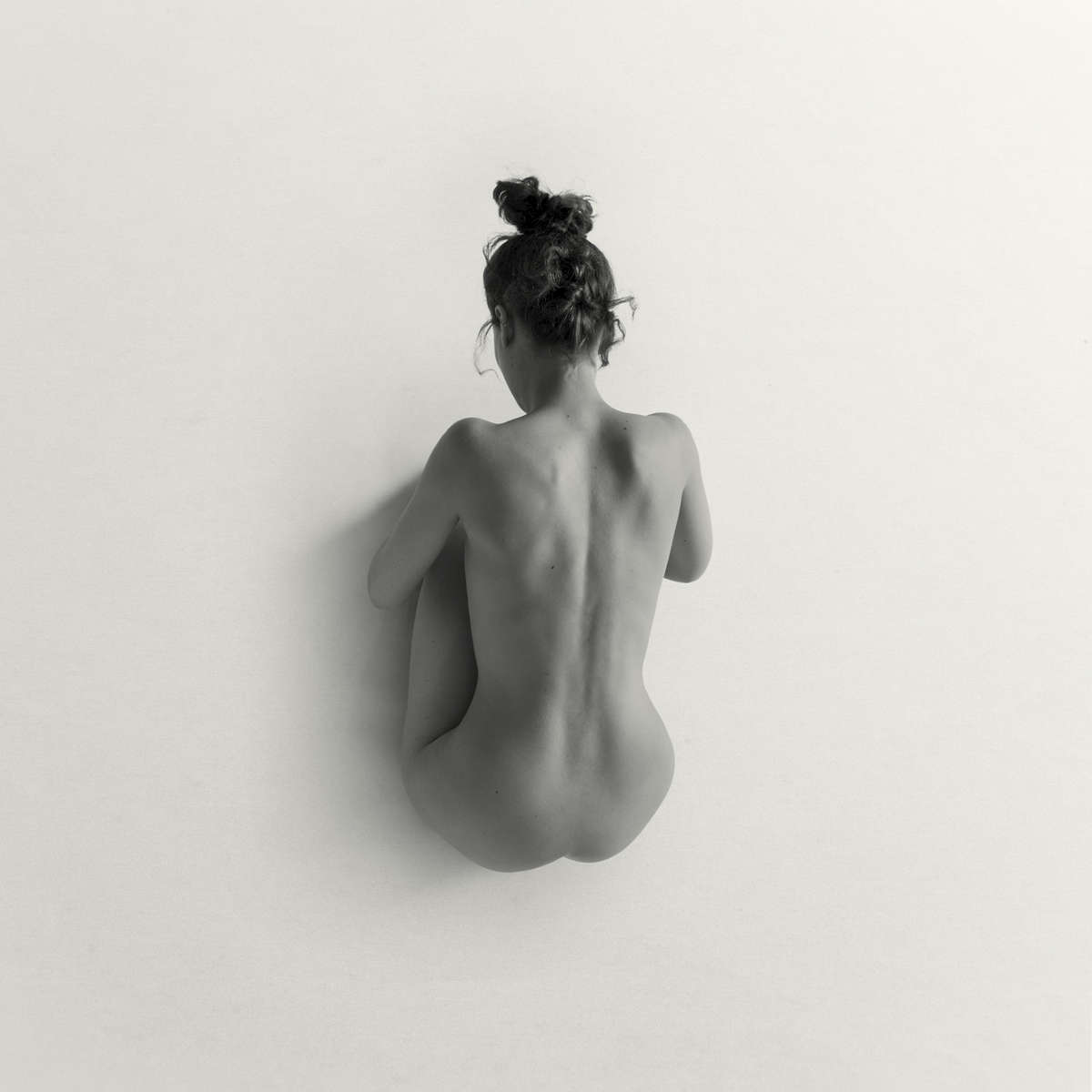 crouching nude woman on white in a studio