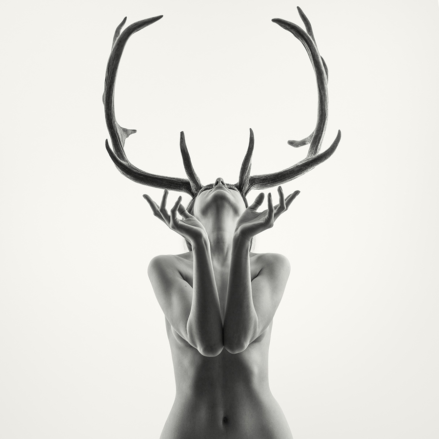 portrait of a nude girl with antlers in the studio
