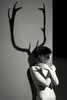 nude female model as mythical god cerynitis with the shadow of antlers