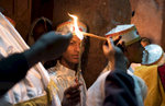Fasika/Easter morning.  The flame of the church at Bete Maryam is lit by a young deacon who carries it to the gathering priests to begin the Midnight Mass.