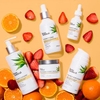 InstaNatural's Vitamin C family of products, photographed on orange with the natural ingredients of citrus and strawberry.