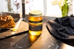 Crystal's Raw Black Locust Honey product photo, back lit by sunset light on dark marble.