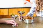 Two friends holding hamered pewter martini glasses and bowl for the Danforth Pewter catalog.