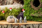 A happy pewter gnome family sit outside their forest home. Advertising photo for the Danforth Pewter catalog.