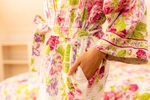 A women shows off her floral patterned night gown's pockets for this catalog photo for April Cornell.