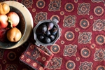 A bowl of dates sits on a red table cloth with matching napkins for the April Cornell catalog.