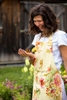 apparel photography of a woman in a apron holding a butterfly for April Cornell