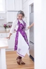 A purple flower patterned apron is worn by a model for an apparel photo shoot for April Cornell.